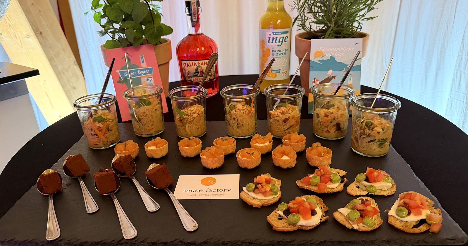 Fingerfood auf einer Schieferplatte: Weckgläser mit Salat, Tartelettes und Crostini