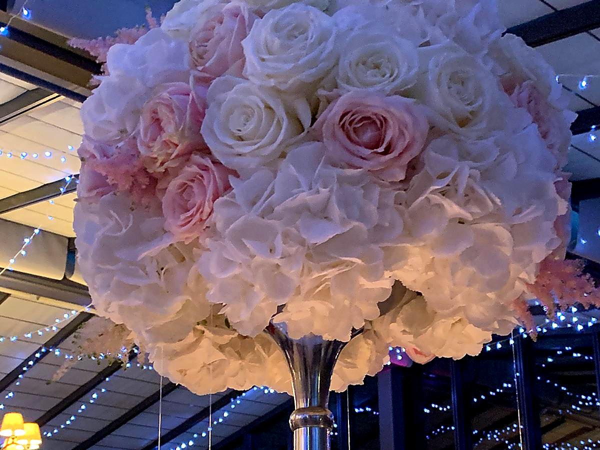 Hohes Blumengesteck aus Hortensien und Rosen auf einer Silbervase