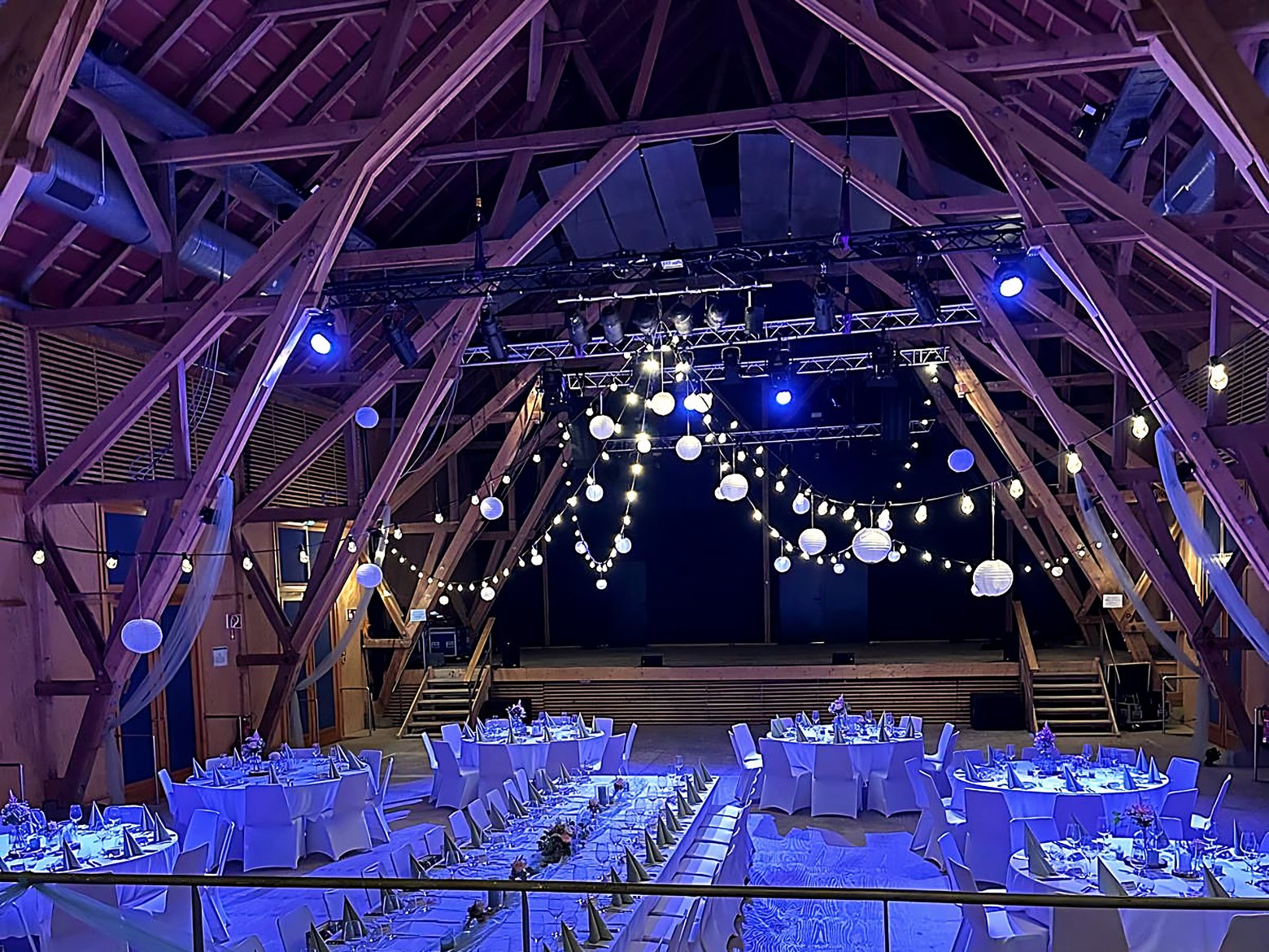 Festhalle mit Holzdachstuhl in blauer Ambientebeleuchtung